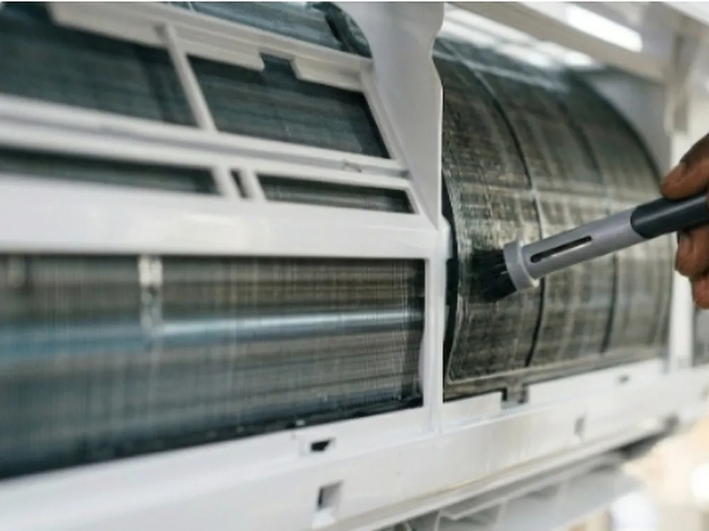 Nettoyage du serpentin d'un climatiseur split avec une brosse